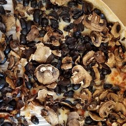 half of a mushroom and black bean pizza