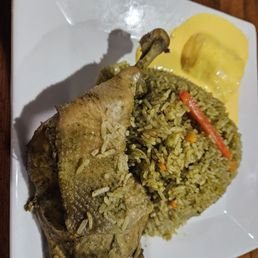 Arrow con Pollo.  Rice cooked with chicken in cilantro sauce, served with onion salsa. Served with salsa criolla.