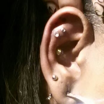 Tattoo Paradise - Two helix piercings above the conch. Completely unique by Brian. #love - Piercing Near Me - Wheaton, Maryland