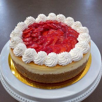 Cherry On Top - a strawberry cheesecake on a white plate - Custom Cakes Near Me