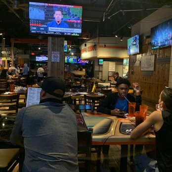 Hooters - a group of people sitting at a table in a restaurant - American Near Me - Orlando, Florida