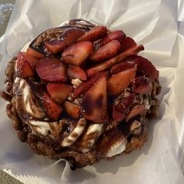 Chocolate funnel cake with strawberries, whipped cream, and chocolate sauce