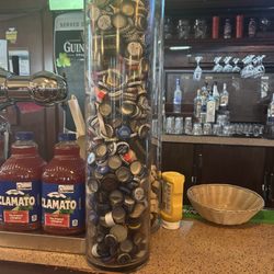 Pearson Pub - A very tall glass tube filled with bottle caps, about 2 feet high