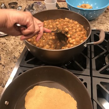 Haneeda's Kitchen - a person stirring food in a pan - Indian Near Me - Glen Mills, Pennsylvania