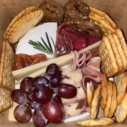 a variety of cheeses, crackers, and meats