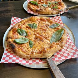 Cheese pizza with basil and meat lover pizza Bueno
