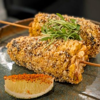 Sushi Saint Winter Park - Japanese Corn Elote (2pc)  Crispy fried corn on the cob, topped with black garlic aioli, cotija cheese, togarashi and lime - Japanese Near Me - Winter Park, Florida