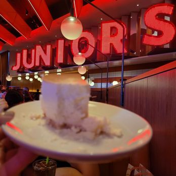Junior's Restaurant & Bakery - Tried to get a good shot with the sign (after a bite). - American Near Me - New York, New York Junior's Restaurant & Bakery - Tried to get a good shot with the sign (after a bite). - American Near Me - New York, New York