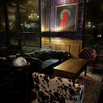 Atlas Fort Worth - a living room with a cow print chair - Bars Near Me - Fort Worth, Texas