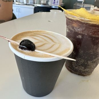 Necessity Coffee - One of the specialties drinks. Right side with the cherry, left drink is the Golden Hour drink - Coffee Roasteries Near Me - Encinitas, California Necessity Coffee - One of the specialties drinks. Right side with the cherry, left drink is the Golden Hour drink - Coffee Roasteries Near Me - Encinitas, California