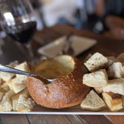 Twisted Vine - Melted Brie cheese baked into a sourdough bowl and served with toasted sourdough bites and fresh apple slices for dipping.