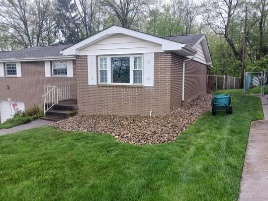 river rock bed transformation - this was a total revamp from a bed that was full of bushes and weeds to a beautiful bed of river rock that the customer later put potted plants and ornamental figurines on top of. call today for 10% off your next project!