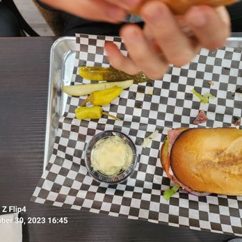 Knockout Deli & Kitchen - a person eating a burger - Sandwiches Near Me - San Diego, California Knockout Deli & Kitchen - a person eating a burger - Sandwiches Near Me - San Diego, California