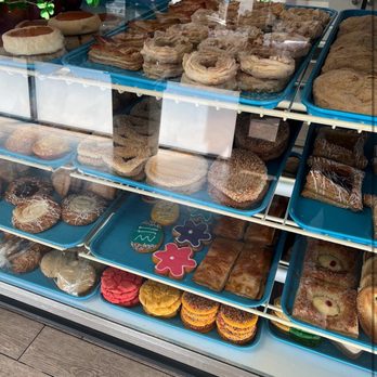 La Purisima Bakery 2 - A bakery display case showcases an assortment of baked items such as donuts, cookies, and pastries arranged on blue trays. - Bakeries Near Me - Phoenix, Arizona