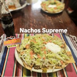 Tivo's Place - Nachos Supreme crunchy corn tortilla chips with fillings topped with a scoop of delicious freshly made guacamole and sour cream.