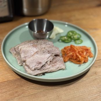 Okdongsik - Naeng Jeyuk - slow-cooked, thinly sliced pork, served with gochuji (chili paste), radish kimchi, peppers, and garlic - Korean Near Me - New York, New York