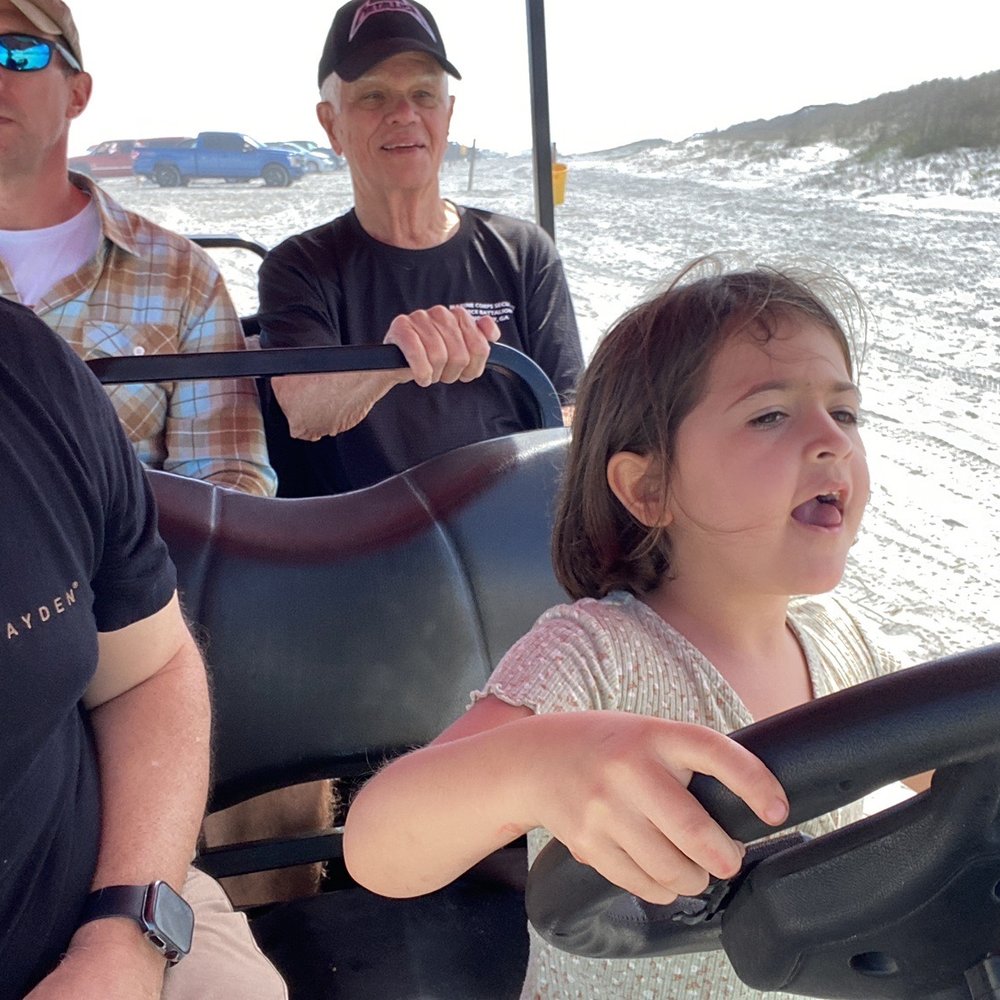 Wild Side Clothing - My daughter pretending to drive a rented golf cart on the beach. - Swimwear Near Me - New Smyrna Beach, Florida Wild Side Clothing - My daughter pretending to drive a rented golf cart on the beach. - Swimwear Near Me - New Smyrna Beach, Florida