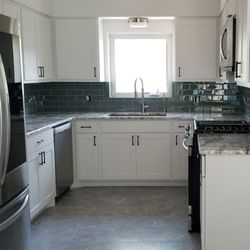 A2Z Granite & Tile - Kitchen and Living area are open. The same quartz slab was used for counter tops in both. Back splash glass tile is a green and a blue.