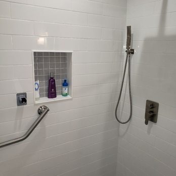 Top Notch Remodeling - a shower with a shower head - General Contractors Near Me