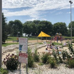 Sun Prairie Family Aquatic Center - Lounge area and playground behind