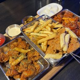 Trio boneless fried chicken platter, comes with tteokbokki in each one as well as dips and sides and a salad. Trio boneless fried chicken platter, comes with tteokbokki in each one as well as dips and sides and a salad.