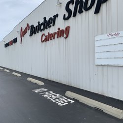 Jim's Butcher Shop & Catering - Side facing gas station to the left, parking lot