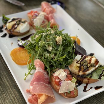 La Fontaine Restaurant - Mixed appetizer plate with prosciutto-wrapped melon, bruschetta, and tomato with cheese, - French Near Me - Mountain View, California La Fontaine Restaurant - Mixed appetizer plate with prosciutto-wrapped melon, bruschetta, and tomato with cheese, - French Near Me - Mountain View, California