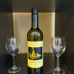 St. Michaels Winery - Vidal Blanc reserve along side two customized St. Michael's wine glasses (with the sails)