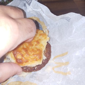 McDonald's - a hand holding a cheeseburger - Burgers Near Me - Lenoir, North Carolina