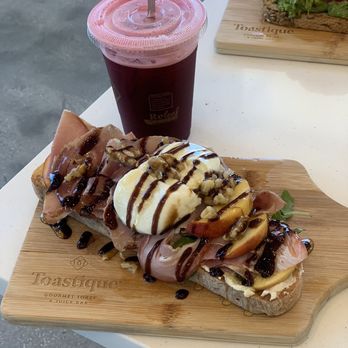 Toastique - Seasonal: peaches, prosciutto, burrata, herbed ricotta, arugula, walnuts, balsamic glaze, hot honey - Juice Bars & Smoothies Near Me - Winter Garden, Florida Toastique - Seasonal: peaches, prosciutto, burrata, herbed ricotta, arugula, walnuts, balsamic glaze, hot honey - Juice Bars & Smoothies Near Me - Winter Garden, Florida