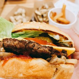 a hand holding a hamburger and fries