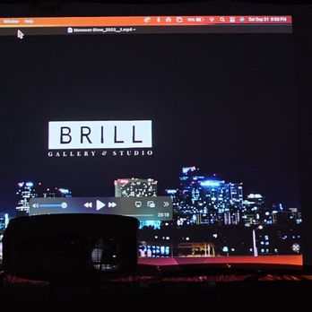 Brill Gallery - A projection screen shows the Brill Gallery & Studio logo over a cityscape at night, with a media player interface visible. - Art Galleries Near Me - Phoenix, Arizona