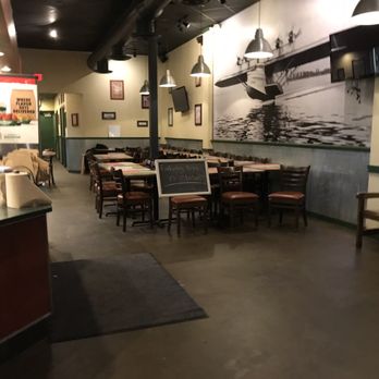 Wingstop - the inside of a restaurant with tables and chairs - Chicken Wings Near Me - Warren, Michigan