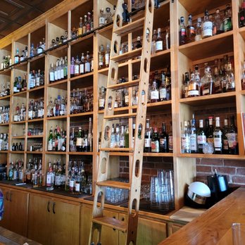 Scotch & Soda - a ladder leaning against a wall of liquor bottles - American Near Me - Bentonville, Arkansas Scotch & Soda - a ladder leaning against a wall of liquor bottles - American Near Me - Bentonville, Arkansas