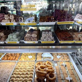 Belmo Cafe - Assorted Turkish delights - A glass display case showcases a variety of Turkish delights, pastries, and baked goods, with labels indicating flavors like gluten-free, Turkish delight, and pistachio rose. - Coffee & Tea Near Me - Berkeley, California