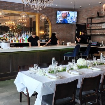 Bocci - a restaurant with a long table and a bar - Italian Near Me - Lasalle, Quebec