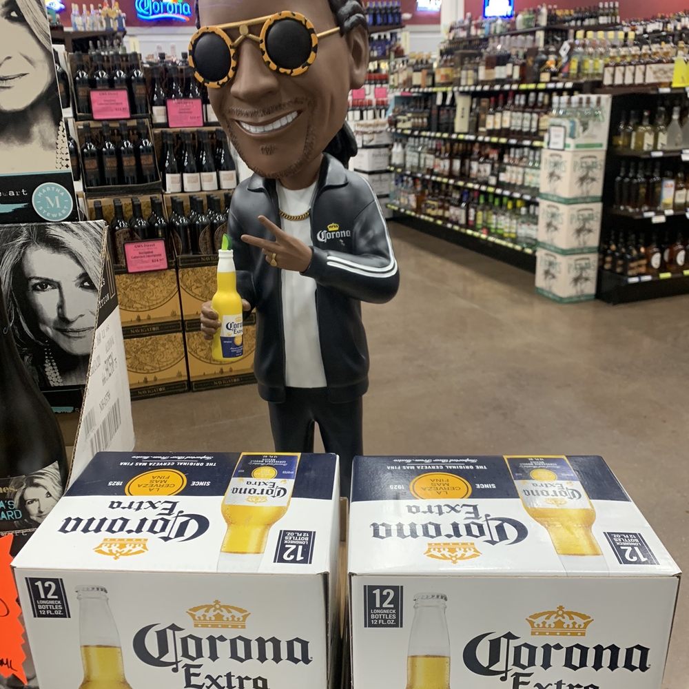 Grand Wine & Spirits - a man in a suit and sunglasses holding a bottle of corona extra - Beer, Wine & Spirits Near Me - Groton, Connecticut