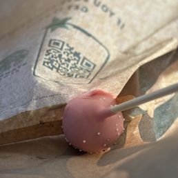 a pink candy lollipop on a brown paper bag