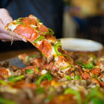 Abby's Legendary Pizza - a person taking a slice of pizza - Pizza Near Me - Myrtle Creek, Oregon Abby's Legendary Pizza - a person taking a slice of pizza - Pizza Near Me - Myrtle Creek, Oregon