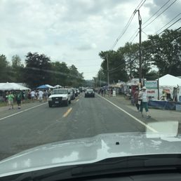 Lots of slow moving traffic and people walking on both sides of the road
