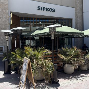 Sipeos Restaurant and Bar - Storefront wide shot: Outdoor seating under the green umbrellas - Mediterranean Near Me - Walnut Creek, California