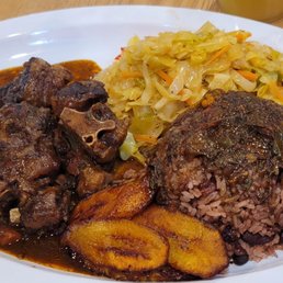 Oxtail plate, the larger one, with the perfectly cooked plantain, oxtail gravy on the rice and peas and delicious seasoned cabbage. Yum! Oxtail plate, the larger one, with the perfectly cooked plantain, oxtail gravy on the rice and peas and delicious seasoned cabbage. Yum!