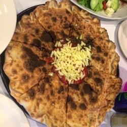 Vulcano: dual-layered pizza with tomato, mozzarella, chilli, olives, anchovies, prosciutto crudo, fresh tomato, salami