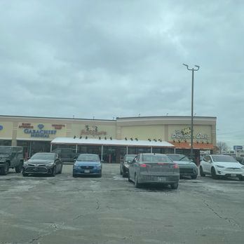 The Blossom Cafe - Front of building. - The image shows the exterior of The Blossom Cafe with a parking lot filled with various cars and a cloudy sky overhead. - Breakfast & Brunch Near Me - Norridge, Illinois