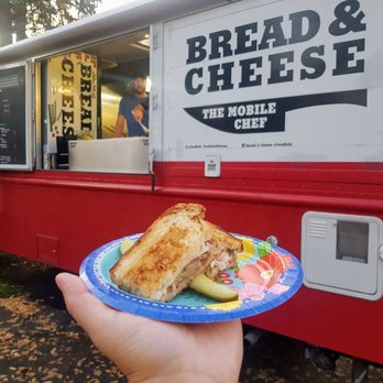 Bread & Cheese Truck - a person holding a plate with a sandwich on it - Food Trucks Near Me
