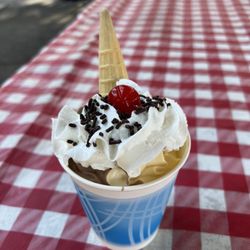 The Burger Shack - Chocolate/Vanilla Swirl (soft serve) on a cone in a cup with chocolate sprinkles and a cherry on top