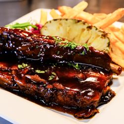 Ohana's Island Bistro & Music - Pauly's Southern Ribs served with a pineapple wedge and fries.