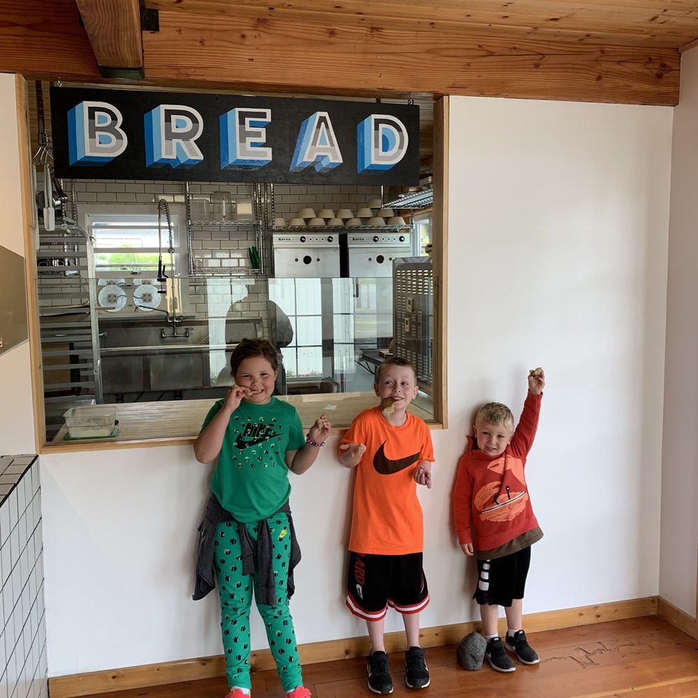 two children standing in front of a window two children standing in front of a window