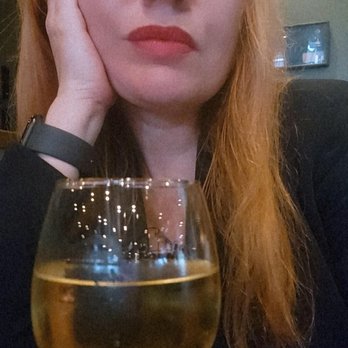 Murph's Irondequoit Pub - a woman sitting at a table with a glass of wine - Pubs Near Me - Rochester, New York