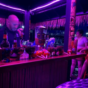 Tiki Hut Boats - 2021 Captain Scott behind the bar and the lights at night - Tiki Bars Near Me - Salem, Massachusetts Tiki Hut Boats - 2021 Captain Scott behind the bar and the lights at night - Tiki Bars Near Me - Salem, Massachusetts